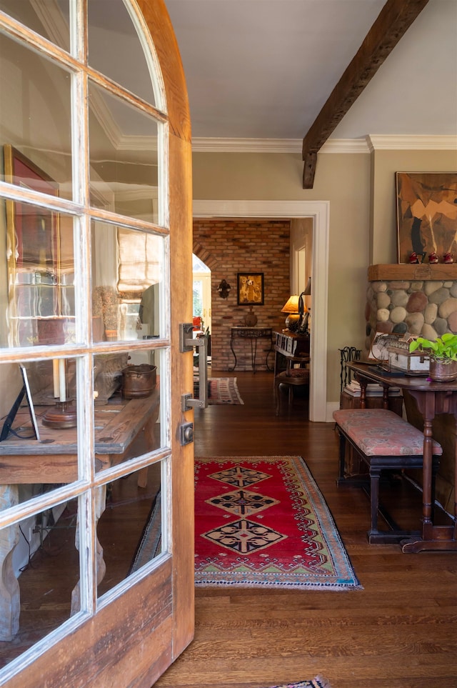 interior space featuring beamed ceiling, dark hardwood / wood-style floors, and ornamental molding