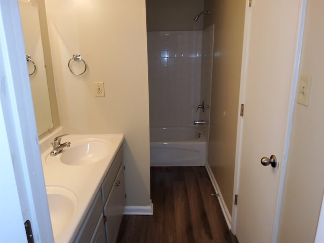 bathroom with hardwood / wood-style floors, vanity, and shower / washtub combination