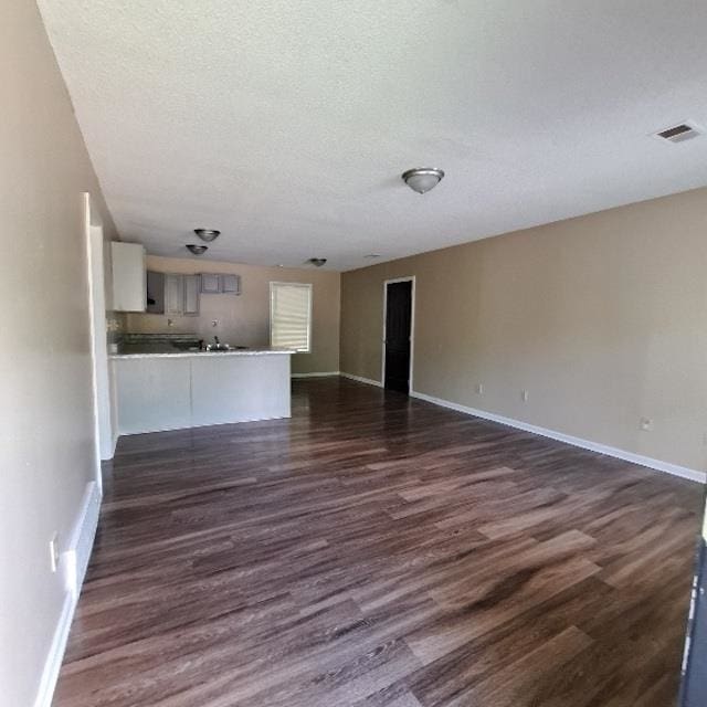 unfurnished living room featuring dark hardwood / wood-style floors and a textured ceiling