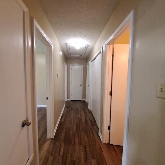 hallway featuring a textured ceiling and dark hardwood / wood-style flooring