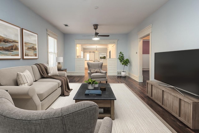 living room featuring dark hardwood / wood-style floors and ceiling fan with notable chandelier