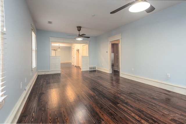 spare room with dark hardwood / wood-style flooring and ceiling fan with notable chandelier