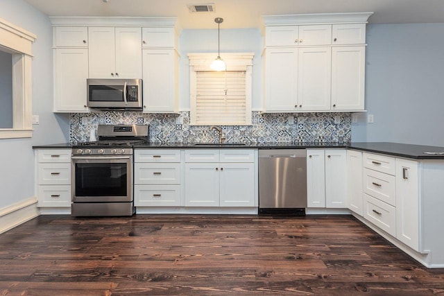 kitchen featuring pendant lighting, stainless steel appliances, dark hardwood / wood-style floors, and sink