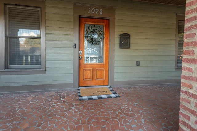 view of exterior entry featuring covered porch