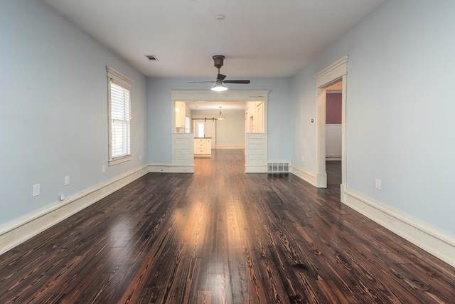 unfurnished living room with ceiling fan and dark wood-type flooring