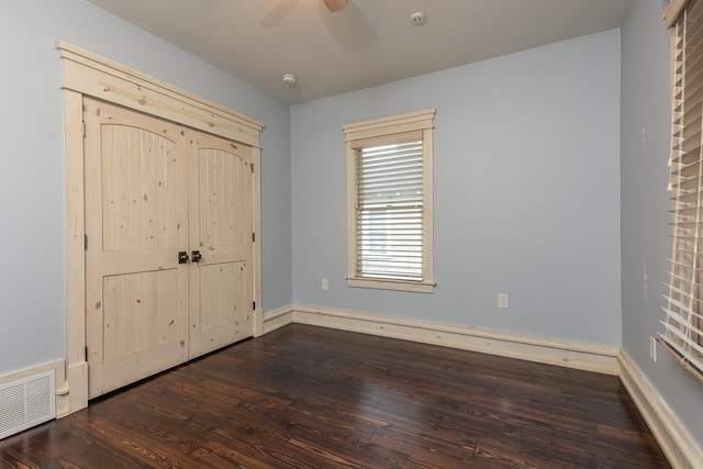 unfurnished bedroom featuring dark hardwood / wood-style floors and ceiling fan