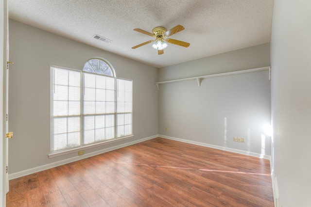 empty room with wood-type flooring, a textured ceiling, and ceiling fan