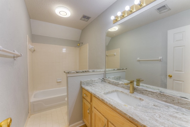 full bathroom featuring vanity, a textured ceiling, vaulted ceiling, toilet, and tiled shower / bath