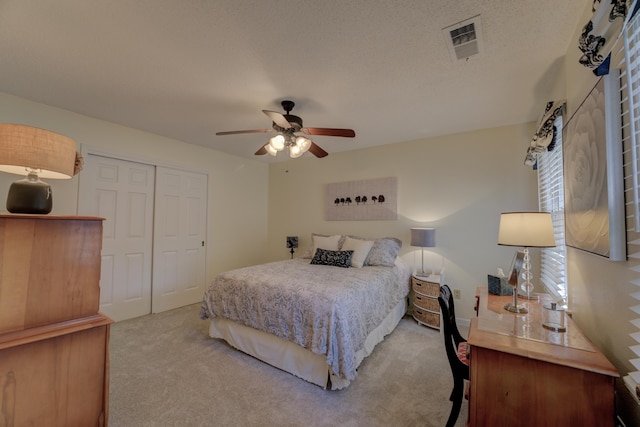 bedroom with ceiling fan, a closet, and light carpet