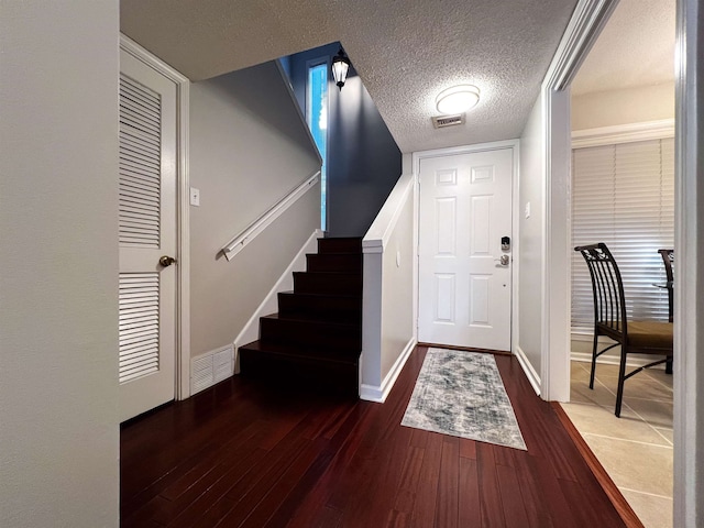 foyer featuring a textured ceiling and dark hardwood / wood-style flooring