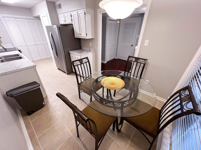 dining area featuring light tile patterned floors and sink