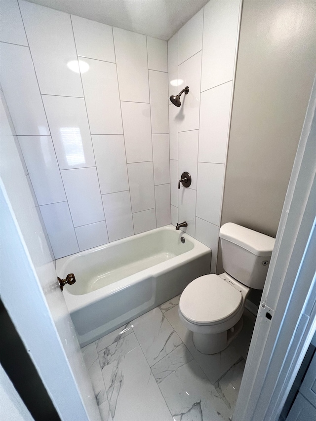 bathroom with toilet and tiled shower / bath