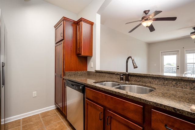 kitchen featuring sink, dishwasher, light tile patterned flooring, ceiling fan, and dark stone counters