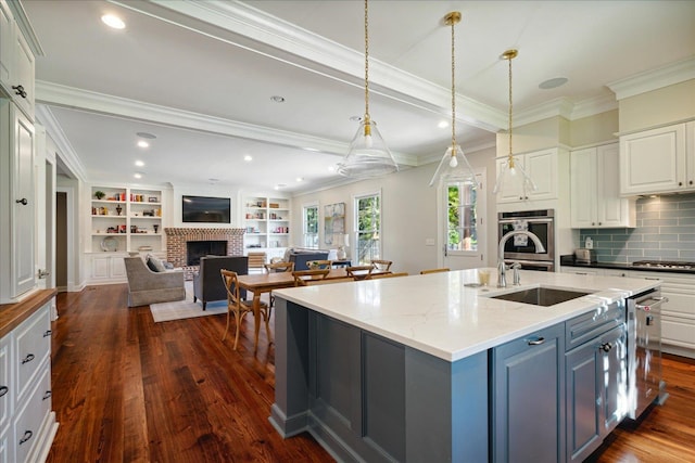 kitchen featuring white cabinets, a brick fireplace, dark hardwood / wood-style floors, ornamental molding, and light stone counters