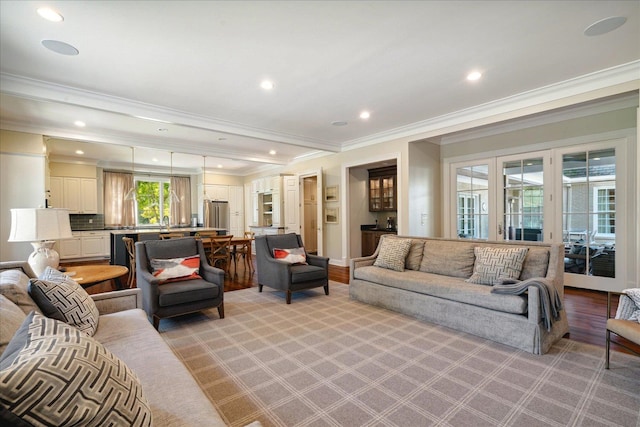 living room with crown molding, light hardwood / wood-style flooring, and french doors