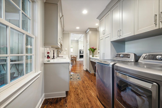 washroom featuring washer and clothes dryer, cabinets, and dark wood-type flooring