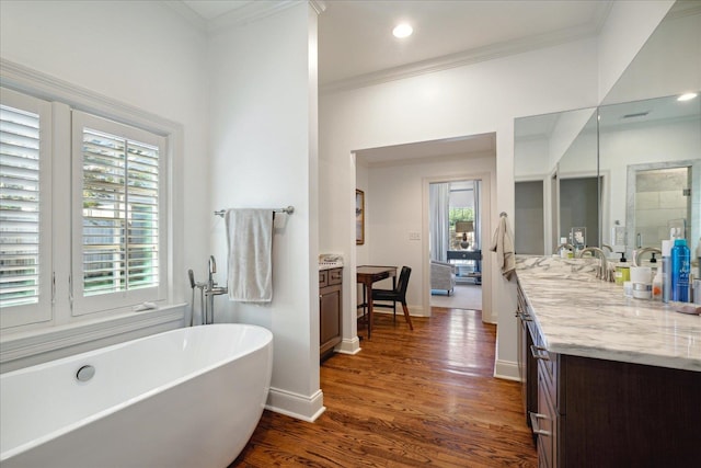 bathroom with a bathtub, wood-type flooring, and ornamental molding