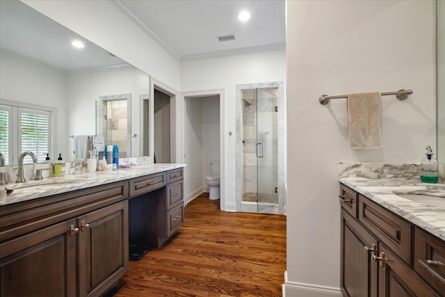 bathroom featuring hardwood / wood-style floors, vanity, toilet, ornamental molding, and an enclosed shower