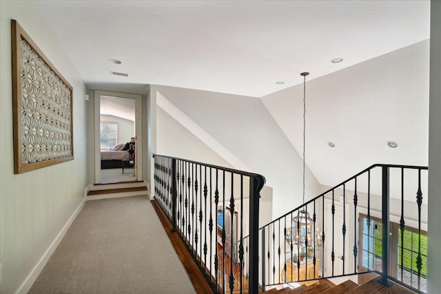 hall with dark carpet, plenty of natural light, and lofted ceiling