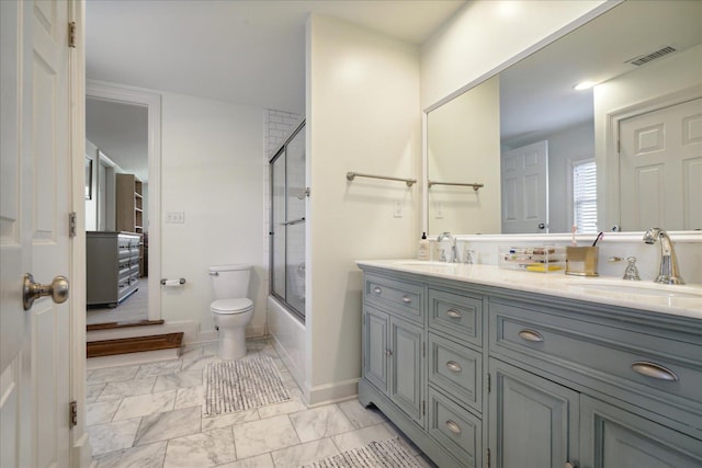 full bathroom with vanity, enclosed tub / shower combo, and toilet