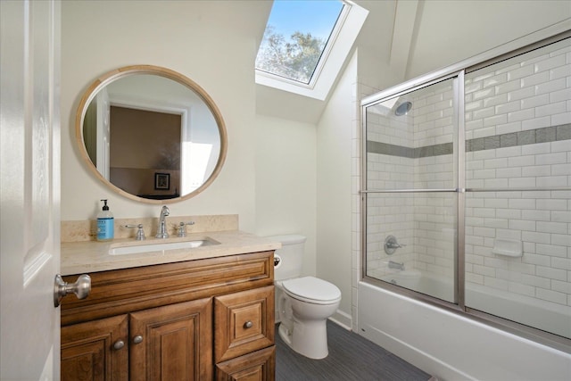 full bathroom featuring enclosed tub / shower combo, tile patterned floors, toilet, vaulted ceiling with skylight, and vanity