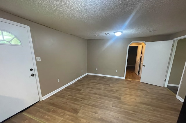 foyer entrance with a textured ceiling and hardwood / wood-style flooring