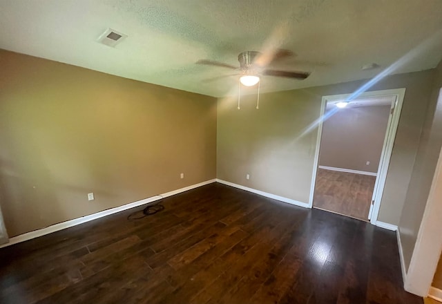 spare room with a textured ceiling, dark hardwood / wood-style flooring, and ceiling fan