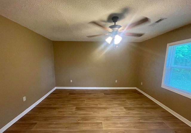 unfurnished room featuring ceiling fan, wood-type flooring, and a textured ceiling