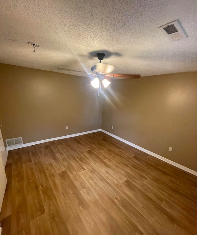 spare room with hardwood / wood-style floors and a textured ceiling