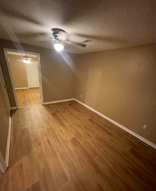 empty room featuring wood-type flooring and a textured ceiling