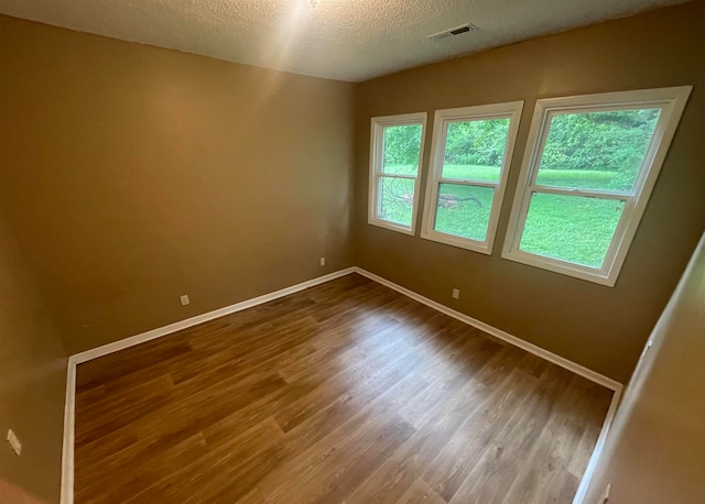 spare room with hardwood / wood-style flooring and a textured ceiling