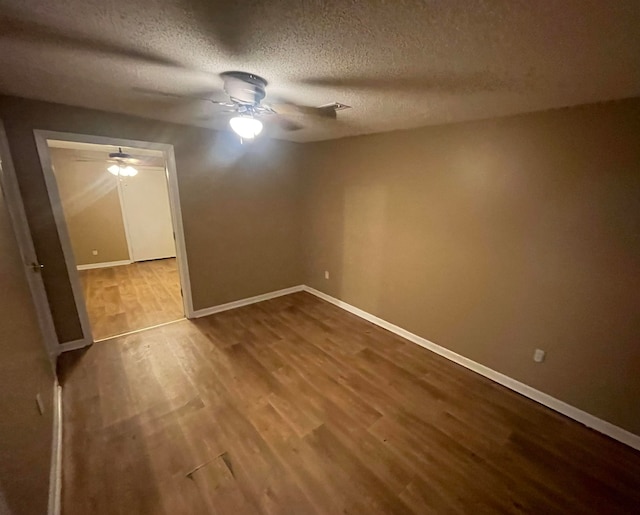 empty room with hardwood / wood-style floors and a textured ceiling