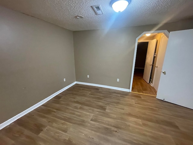 spare room with wood-type flooring and a textured ceiling