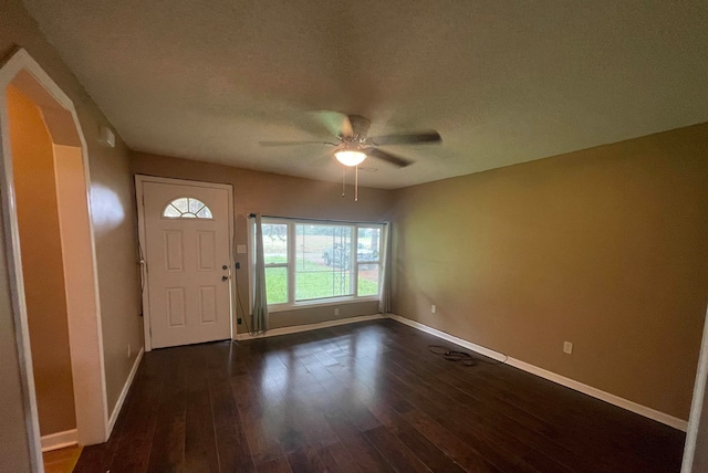 entrance foyer with a textured ceiling, ceiling fan, and dark wood-type flooring