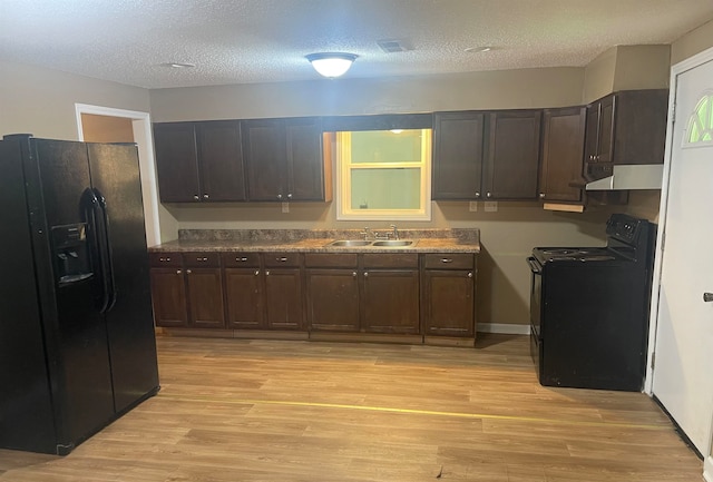 kitchen with black appliances, dark brown cabinetry, light wood-type flooring, and sink