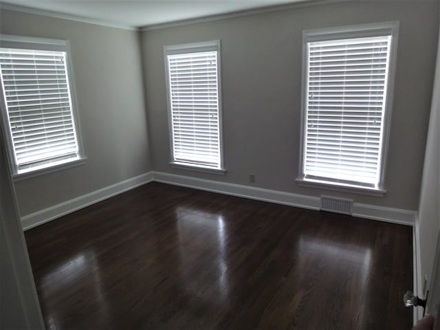 empty room featuring crown molding and dark wood-type flooring