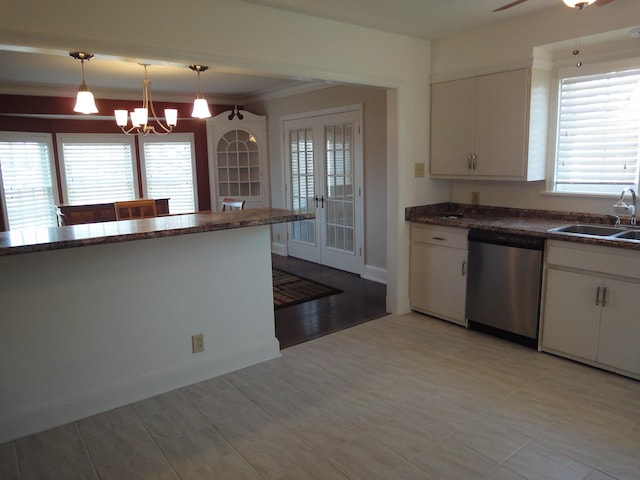 kitchen featuring decorative light fixtures, white cabinetry, stainless steel dishwasher, and sink