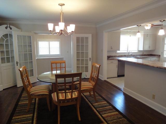 dining area with hardwood / wood-style floors, crown molding, a wealth of natural light, and a chandelier