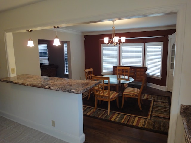 kitchen featuring kitchen peninsula, dark hardwood / wood-style floors, hanging light fixtures, and a notable chandelier