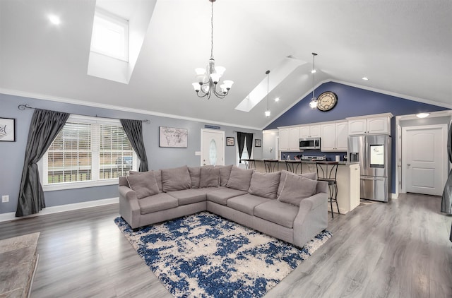 living room featuring a skylight, hardwood / wood-style flooring, an inviting chandelier, and ornamental molding