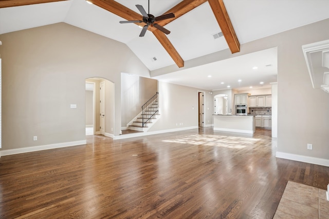 unfurnished living room featuring hardwood / wood-style floors, lofted ceiling with beams, and ceiling fan