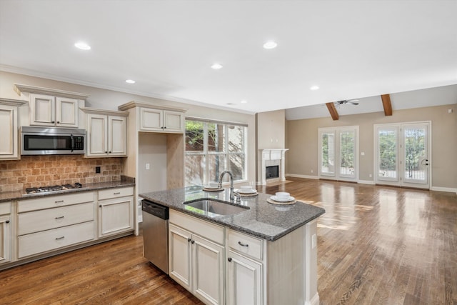 kitchen featuring ceiling fan, hardwood / wood-style floors, cream cabinetry, and appliances with stainless steel finishes