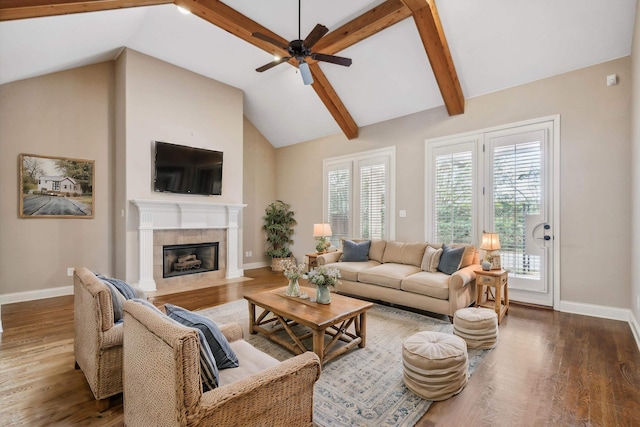 living room with high vaulted ceiling, a tile fireplace, ceiling fan, beam ceiling, and dark hardwood / wood-style flooring