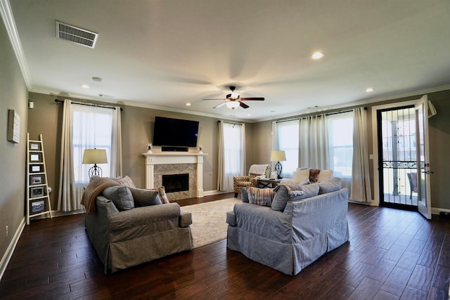 living room with crown molding, plenty of natural light, and dark hardwood / wood-style flooring