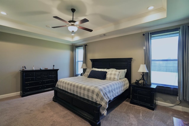 carpeted bedroom featuring a raised ceiling, ornamental molding, and ceiling fan