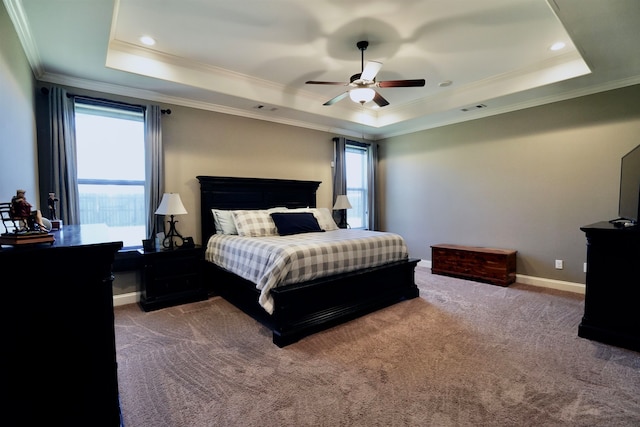 carpeted bedroom featuring ceiling fan, ornamental molding, and a tray ceiling