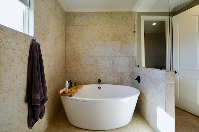 bathroom featuring ornamental molding, tile walls, tile patterned floors, and a bathtub