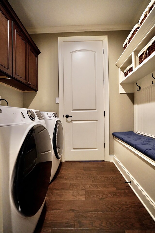 clothes washing area featuring cabinets, crown molding, dark wood-type flooring, and washing machine and clothes dryer