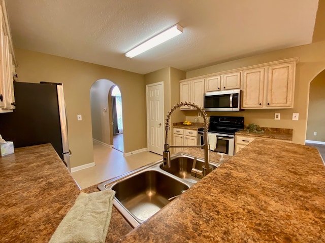 kitchen featuring appliances with stainless steel finishes, a textured ceiling, and sink