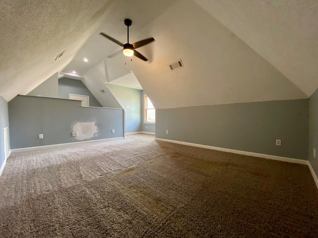 bonus room featuring a textured ceiling, carpet floors, vaulted ceiling, and ceiling fan